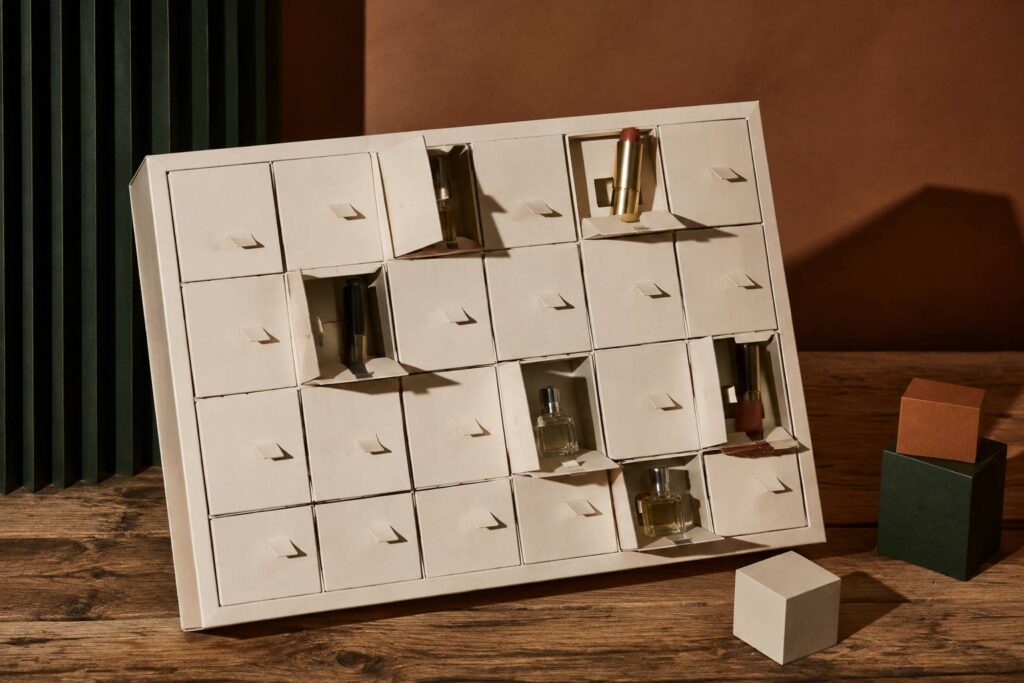 Coffret calendrier de l'Avent cosmétique en carton kraft aux cases entrouvertes sur des écrins sans marque